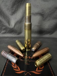 various sizes of .416 rigby bullets with a single fully assembled bullet standing in the middle.
